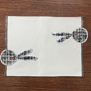 Obrúsok v sivej farbe so zajačikmi